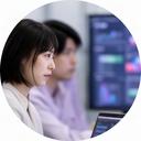 データ分析画面を見ながら打ち合わせをする日本人女性AIエンジニア